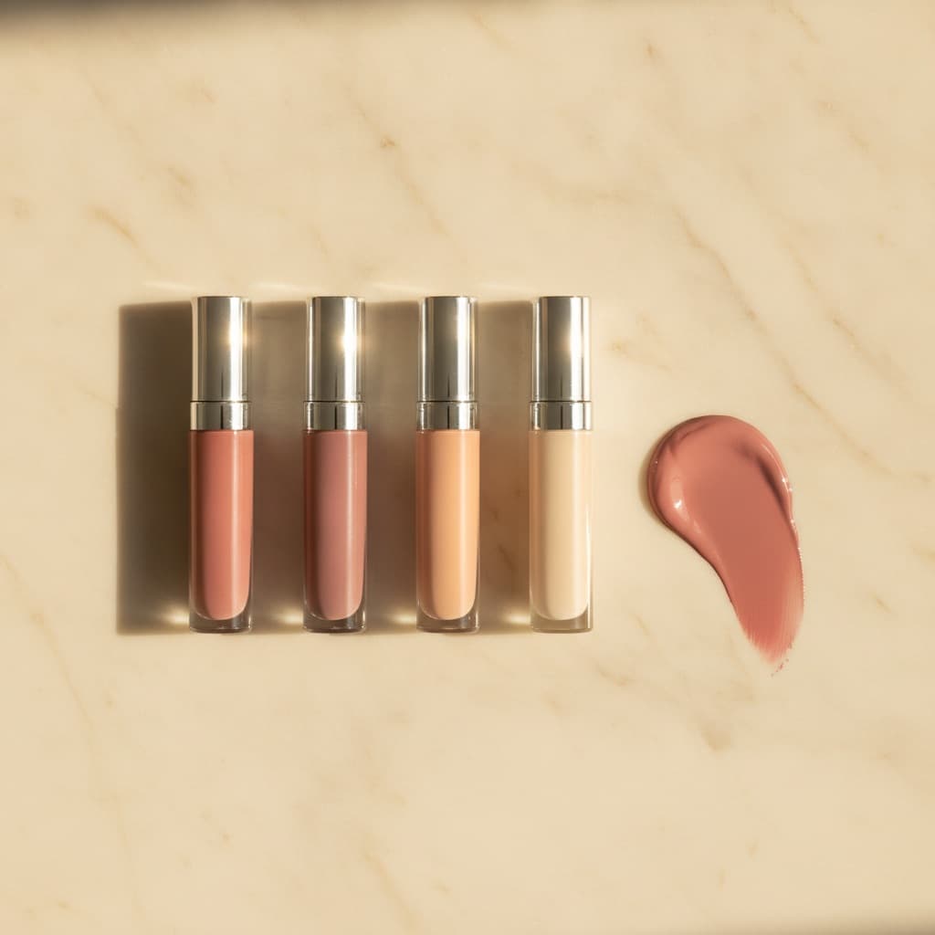 Blush liquide rosé et ses dupes alignés sur fond crème, gouttes de produit, lumière douce éditoriale