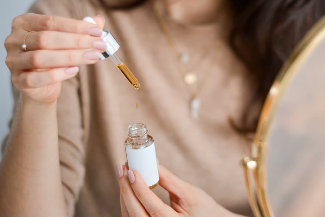 Facial oils in elegant dropper bottles on warm marble