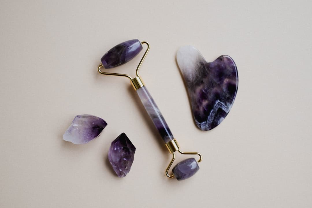 Facial gua sha and roller tools on marble surface